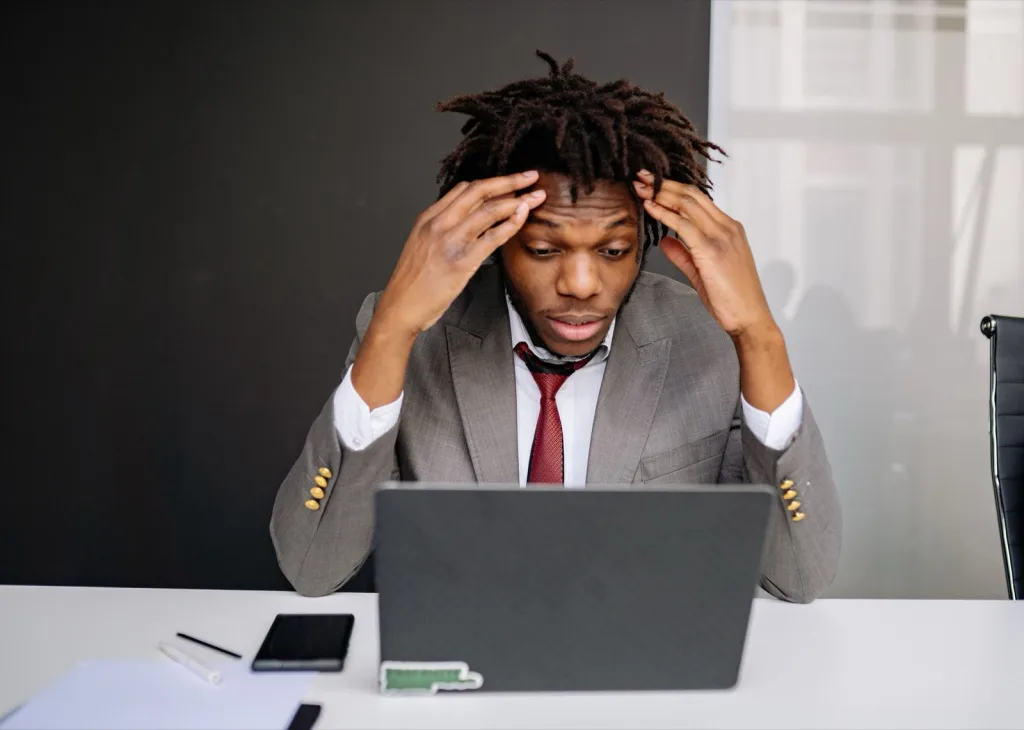 Titolare di una piccola attività guarda pensieroso il sito sul laptop